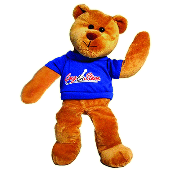 A plush bean bag teddy bear with a blue t-shirt featuring the text 'Greg & Steve'. The teddy bear has a brown color and is posed as if waving.